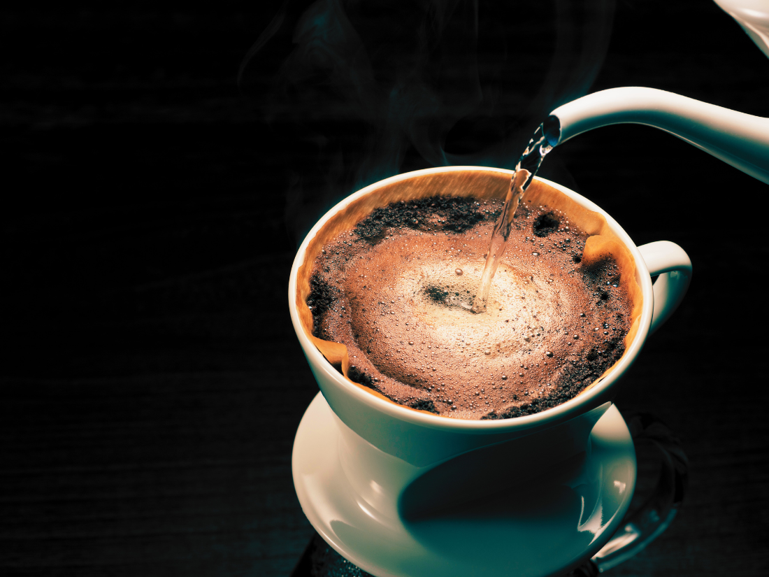 Close-up of a creamy latte in a white cup, showcasing latte art from Palm Beach Coffee Co