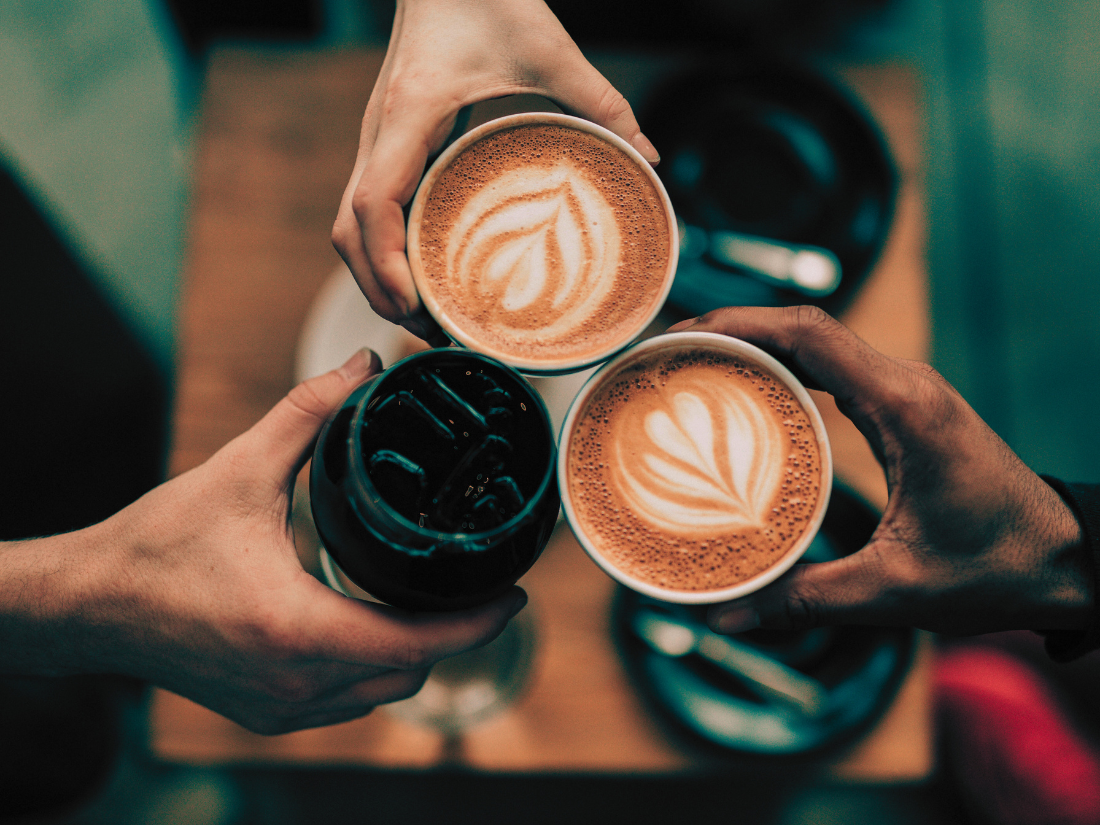 Three people holding cups of light, medium, and dark roast coffee from Palm Beach Coffee Co.